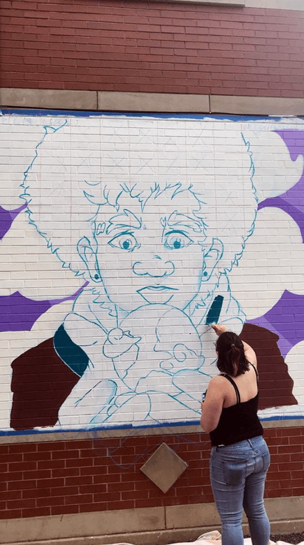 Rachel Nurmi painting a mural